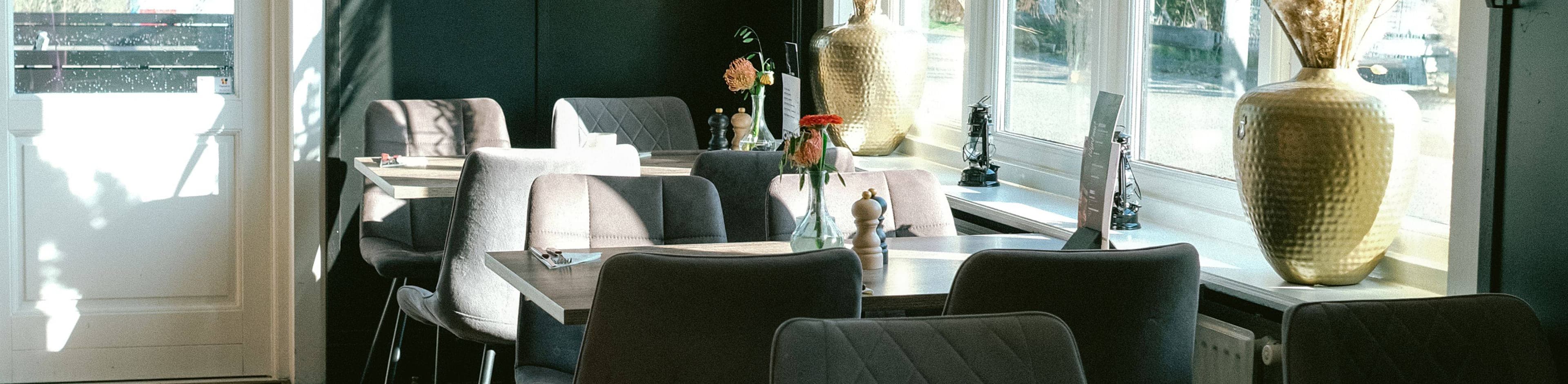 Gastvrije sfeer bij Jack's Colony Grill, met een stijlvol interieur en een uitnodigende tafel voor een unieke grillervaring